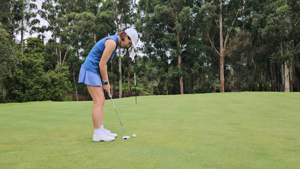 istock Woman in a Blue Dress Playing Golf 2140836973