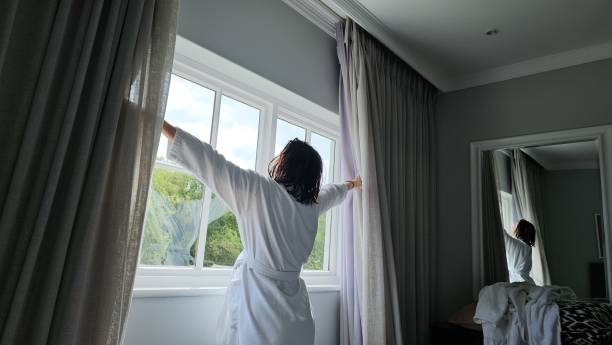 istock Woman in Robe Standing in Front of Window 2140836976