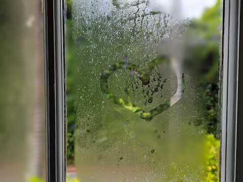 A detailed shot of a window with a heart shape drawn on it