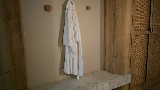 istock White Robe Hanging Next to a Door 2140839561
