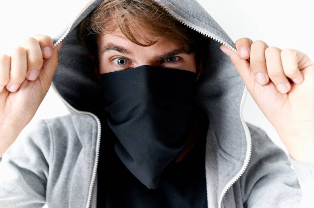 istock man with a hood on his head theft crime Studio light background 2140855158