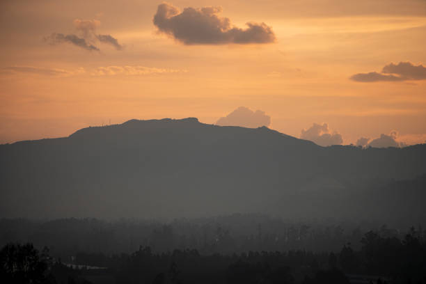 Sunrise with the mountain in the background turning orange in the sky.