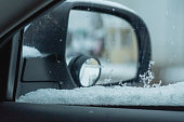 Car side mirror covered in snow winter weather