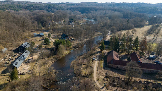 Drone photography or rural landscape and a few houses near a river during sunny spring day