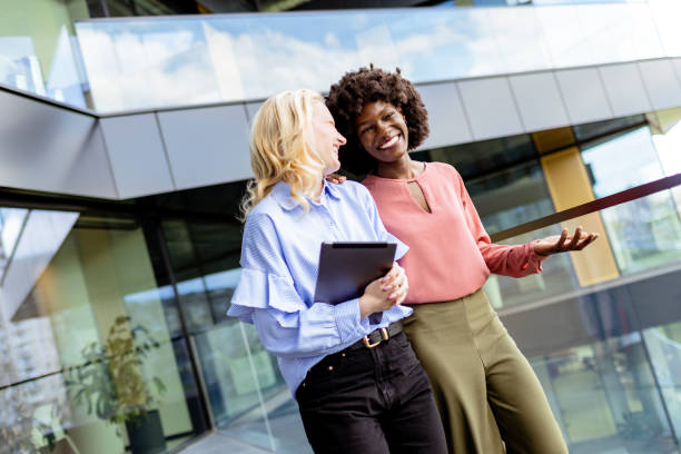 istock Two Professional Women Sharing a Joyful Conversation at a Modern Office Building 2140897752