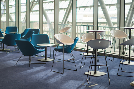 Modern chairs and armchairs in an ultra-modern glass-walled blue carpeted room
