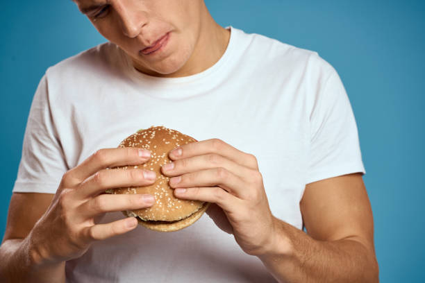 istock man with hamburger and white t-shirt blue background emotions gesturing with hands Copy Space 2140938754
