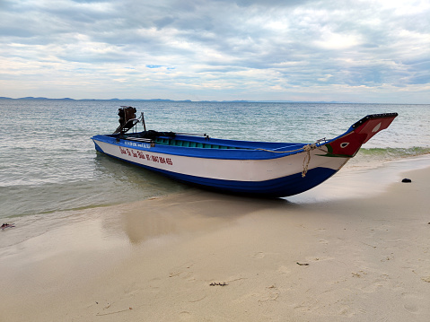 Boat on the shore at Starfish beach, a beautiful beach famous for the many starfishes on the north coast of Phu Quoc island, Vietnam.