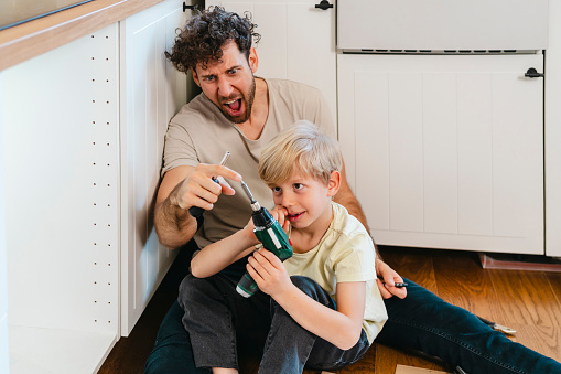 Father and son assembling kitchen furniture