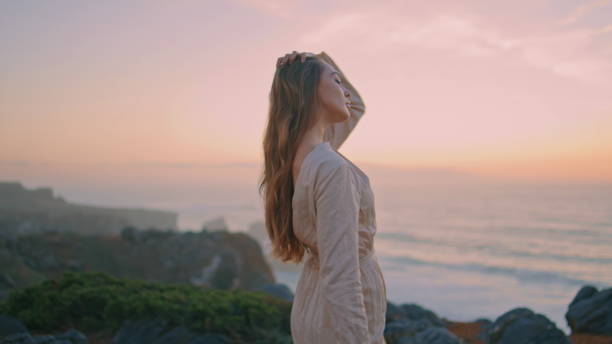 istock Tender woman standing evening hill at ocean view closeup. Model looking camera 2141014064