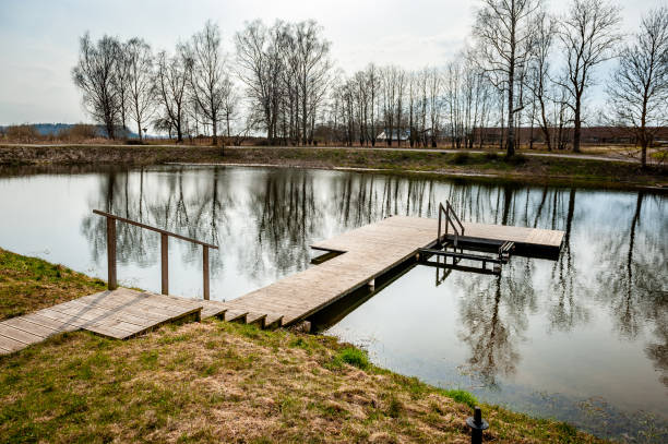 istock Wooden bridge in spring time with blue lake. 2141034443