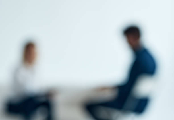 A woman psychologist with documents sits on the couch and a man . High quality photo