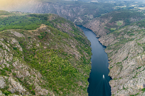 touristic cruise sailing along the Sil river canyon, aerial view with drone Ribeira Sacra.