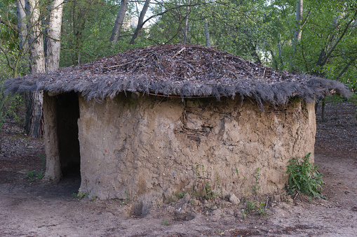 a clay house with a thatched roof from the ancient times of prehistoric man