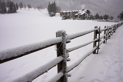 Winter landscape, a wooden fence covered with snow