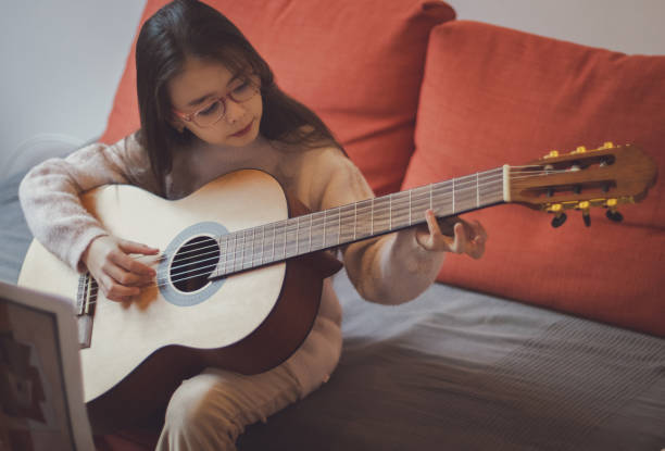 istock Little girl plays the guitar. 2141103312