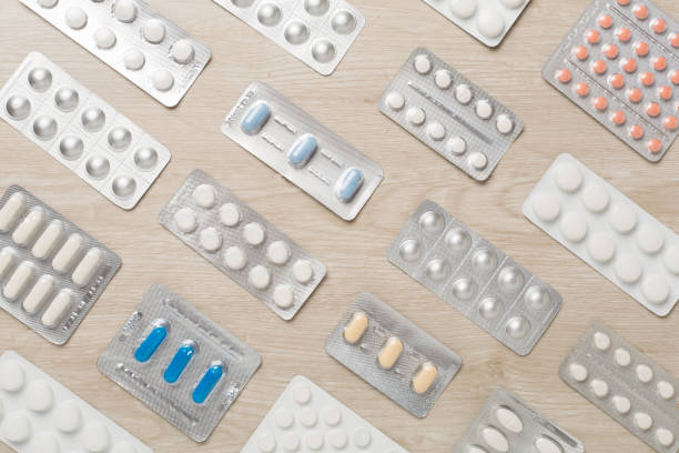 istock Pills in blister packaging on wooden background, top view 2141110853