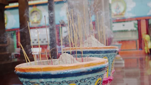 Detail of some incense sticks burning in a Buddhist or Taoist temple