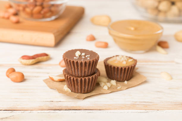 Tasty chocolate peanut butter cups on wooden table