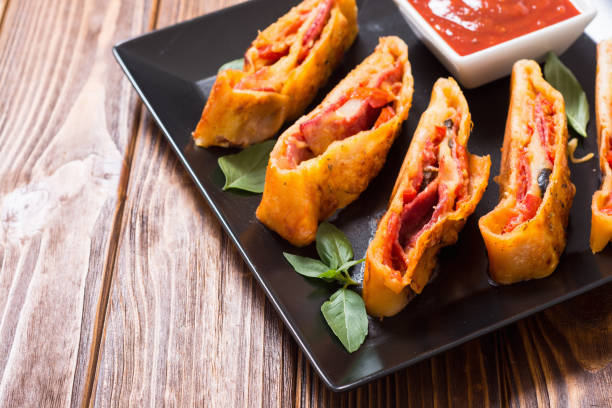 Italian food Pizza roll stromboli with cheese , salami , olives and tomatoes