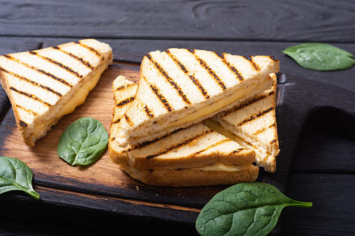 Grilled sandwiches with cheese . Fresh homemade breakfast on rustic background