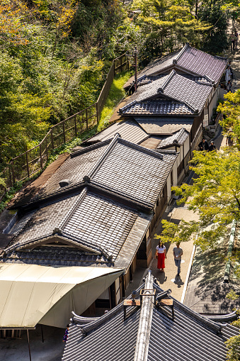 Kyoto, Japan - October 10th, 2023: A row of traditional Japanese tiled roof shops below the hills of the Kiyomizu-dera.