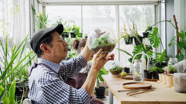 Smiling teacher working with a group of mature friends during a terrarium making class