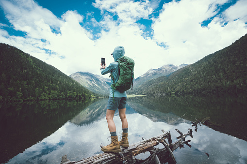 Woman walking on a one plank bridge in high altitude mountains