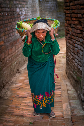 Nepali woman selling a white radish near Durbar Square in Bhaktapur, Nepal. Bhaktapur is an ancient town in the Kathmandu Valley and is listed as a World Heritage Site by UNESCO for its rich culture, temples, and wood, metal and stone artwork.