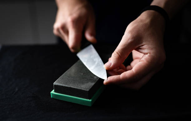 istock Male Hands Sharpening Kitchen Knife With Whetstone 2141181582