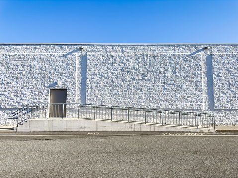 Warehouse entrance on a concrete wall by the side of an asphalt road