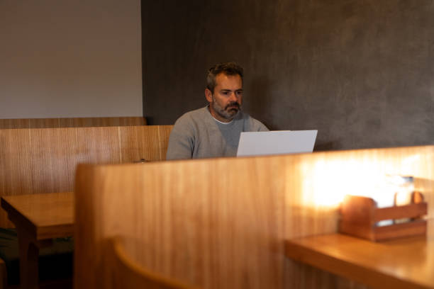 istock Hispanic mature man working remotely in a coffee store 2141255826