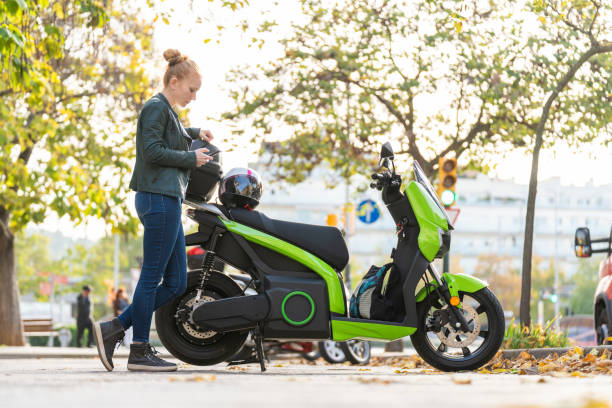 istock Red-haired woman using the smart phone next to her parked motorcycle 2141263769