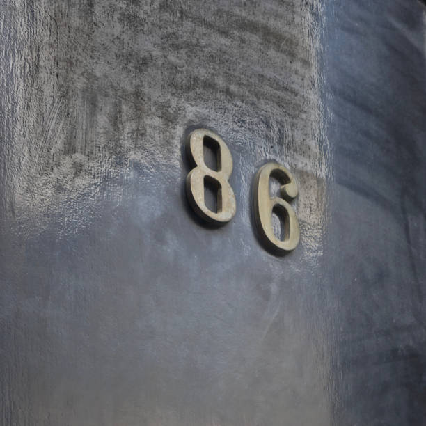 Metal material. Number eighty six (86) on a shiny glossy dark surface.