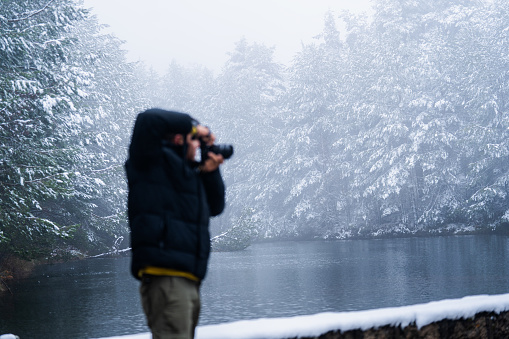Peruvian photographer captures wintry beauty of snowy forest and icy lake landscape.