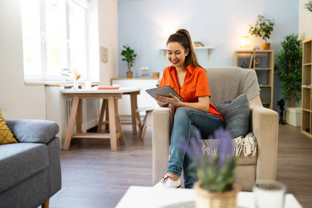 istock Young Caucasian woman using digital tablet while relaxing at home 2141279764
