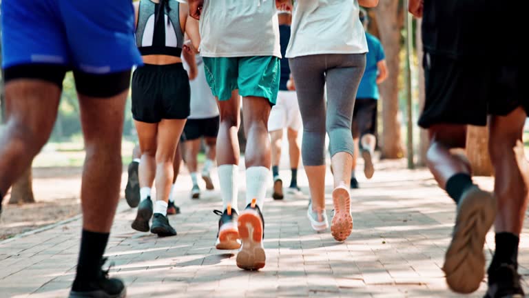Group, legs and running for practice, fitness and exercise in park for urban marathon club in Dallas. Diversity, people and sneakers for cardio, health and wellness as workout, training and sport
