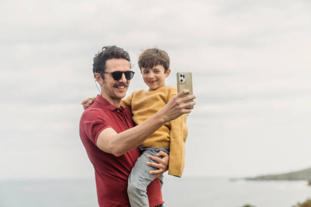 istock Father and son taking selfie at sunny public park 2141317477