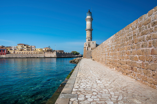 Scenery with beautiful ancient lighthouse surrounded by the sea. Seaport Chania, Crete island, Greece.