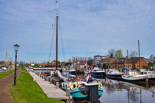 Zoutkamp, Netherlands, Apr. 22, 2023. The harbor of the traditional fishing town of Zoutkamp, province of Groningen, the Netherlands. In the foreground a traditional Dutch sailing barge.