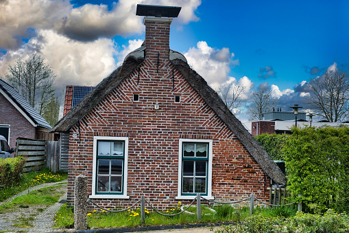Kollum, Netherlands, Apr.27, 2023. Typical 18-th century Frisian farm worker's cottage with a thatched roof in Kollum, province of Friesland, the Netherlands