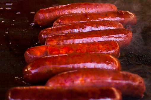 Barbecue grill, chorizos, spanish sausages, prepared in a market stall. Lugo province, Galicia, Spain.
