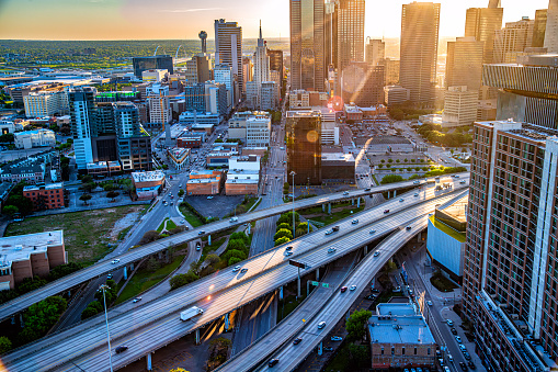A large freeway bisecting downtown Dallas Texas shot via helicopter from an altitude of about 500 feet near sunset.