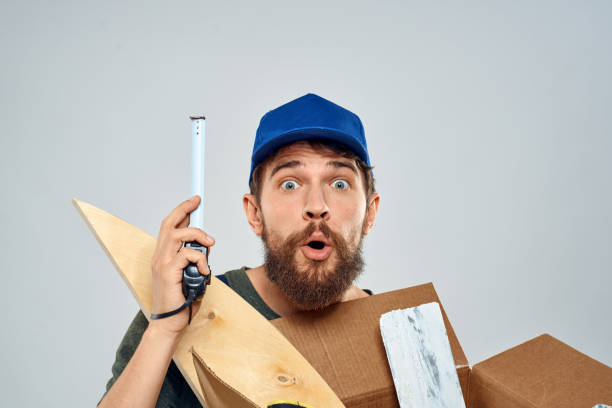istock man in work uniform with box in hands tools lifestyle light background 2141427667