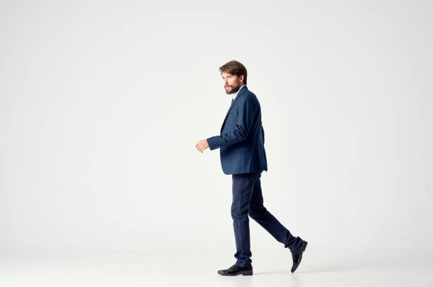 business man in a suit goes to the side on a light background side view Copy Space. High quality photo