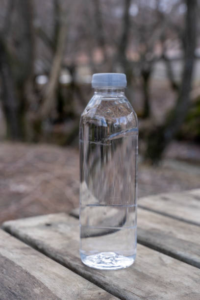 istock Mineral water bottle against light and trees. 2141455764