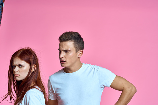 enamored man and woman hugging each other on a pink background cropped with Copy Space family portrait. High quality photo
