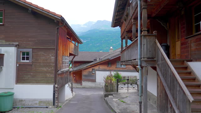 Swiss street with traditional wooden Chalets, Small Town in Switzerland, rural mountains