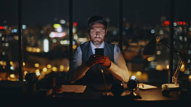 istock Manager texting cellphone overtime at dark cityscape closeup. Focused man using 2141517779