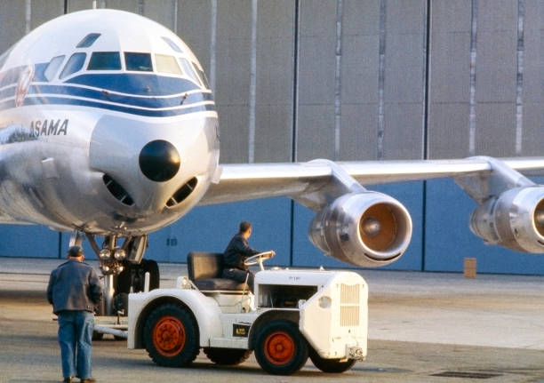 Long Beach, California, USA - about 1965: Japan Airlines (JAL) Douglas DC-8-55F Asama airplane being towed with a tug. This version of the DC-8 could carry passengers, freight or a combination with a movable divider.